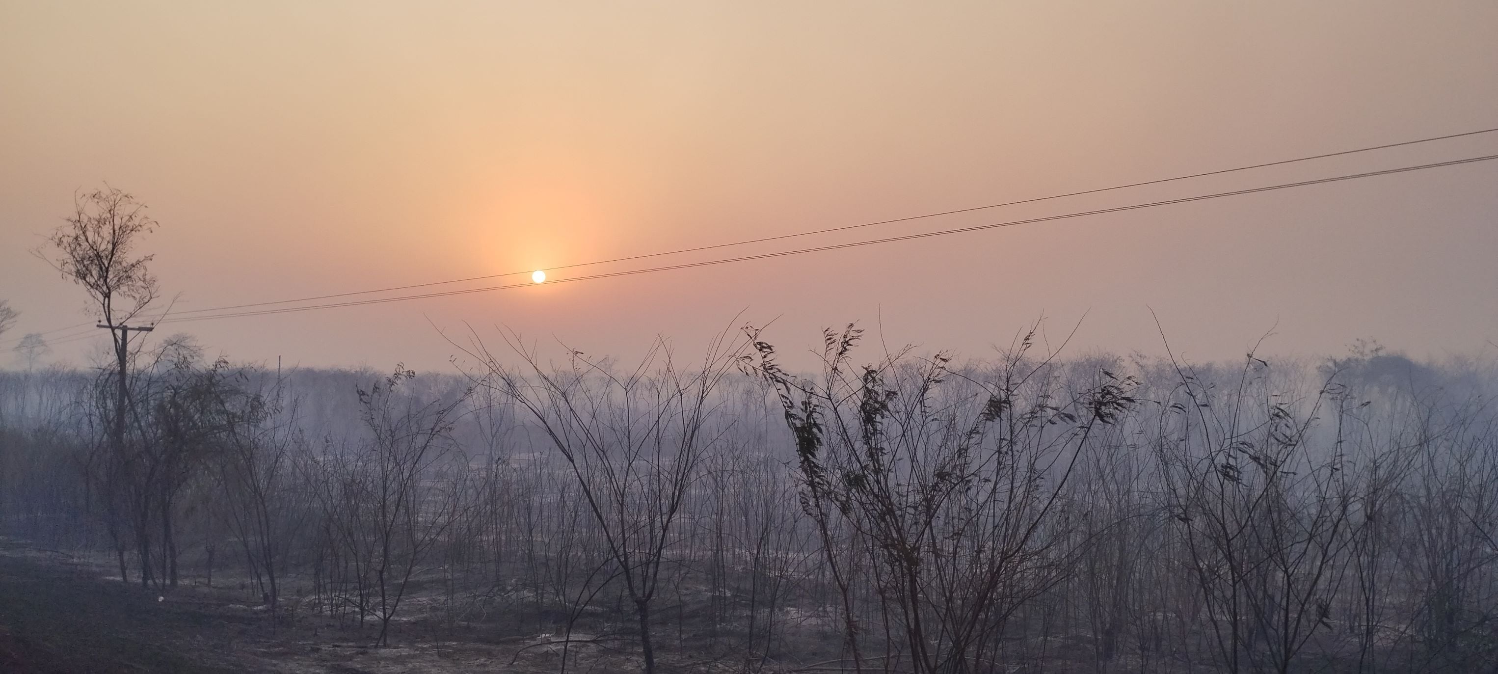 La atmósfera densa sólo permite el paso de los rayos infrarrojos del sol, en el atardecer de las Yungas afectadas por el fuego, en Jujuy.