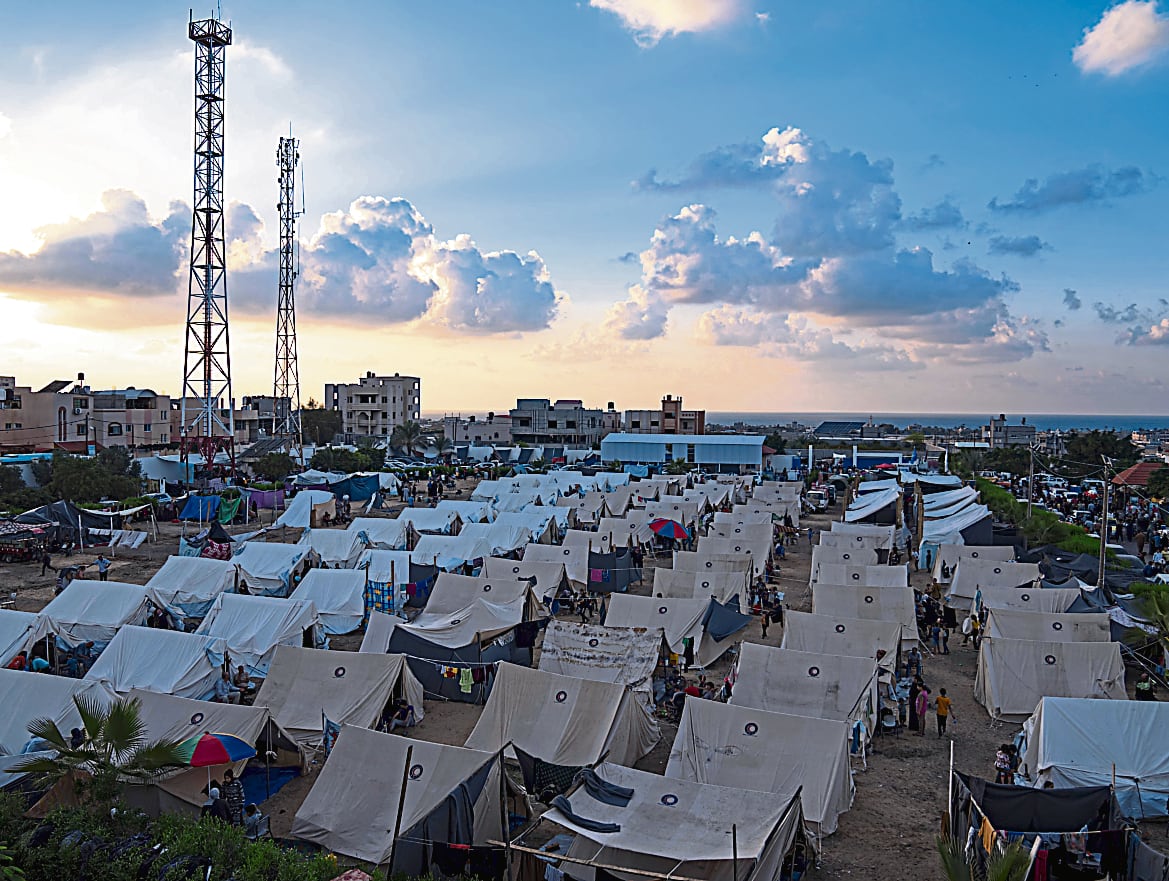 Palestinos desplazados del sector norte de Gaza esperan ayuda humanitaria en un campamento de la ONU.