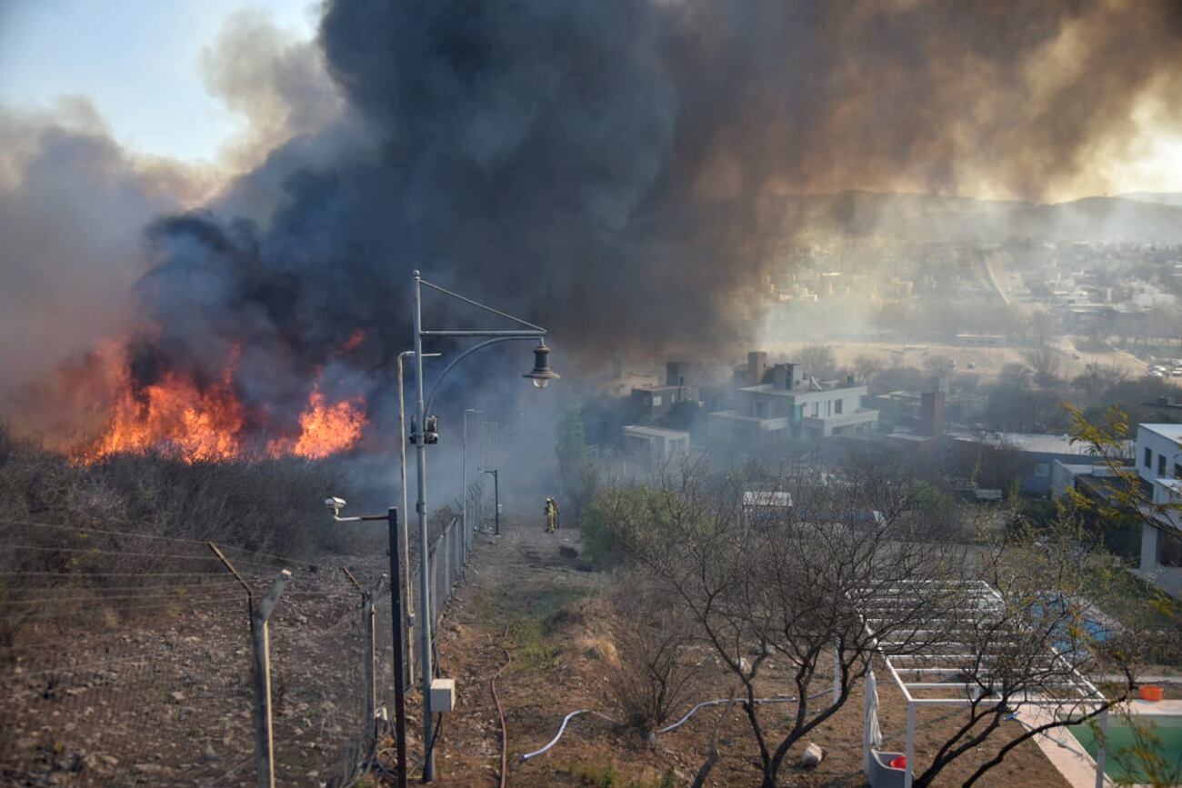 Fuego en Córdoba. Intenso trabajo de los bomberos para contener el incendio en el country La Cuesta, de La Calera. (Facundo Luque / La Voz)