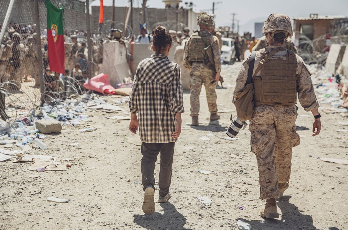 Un infante de Marina, al escoltar a una niña en un puesto de control durante una evacuación en el aeropuerto de Kabul, el jueves. (Cuerpo de Marines de EE.UU./Sargento Víctor Mancilla/AP)