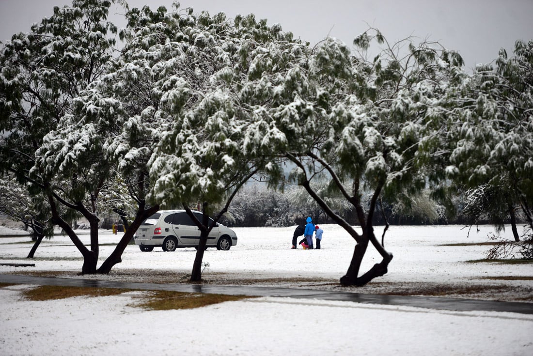 Una intensa nevada cayó en la provincia de Córdoba durante la noche y parte de la mañana del miércoles. 
Parque de los Niños Urbanos, frente al aeropuerto.  Familias juegan y arman muñecos de nieve.  (Nicolás Bravo)