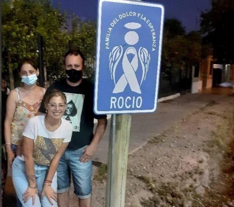 Los padres de Rocío junto a su hermana menor en el lugar donde colocaron el cartel.