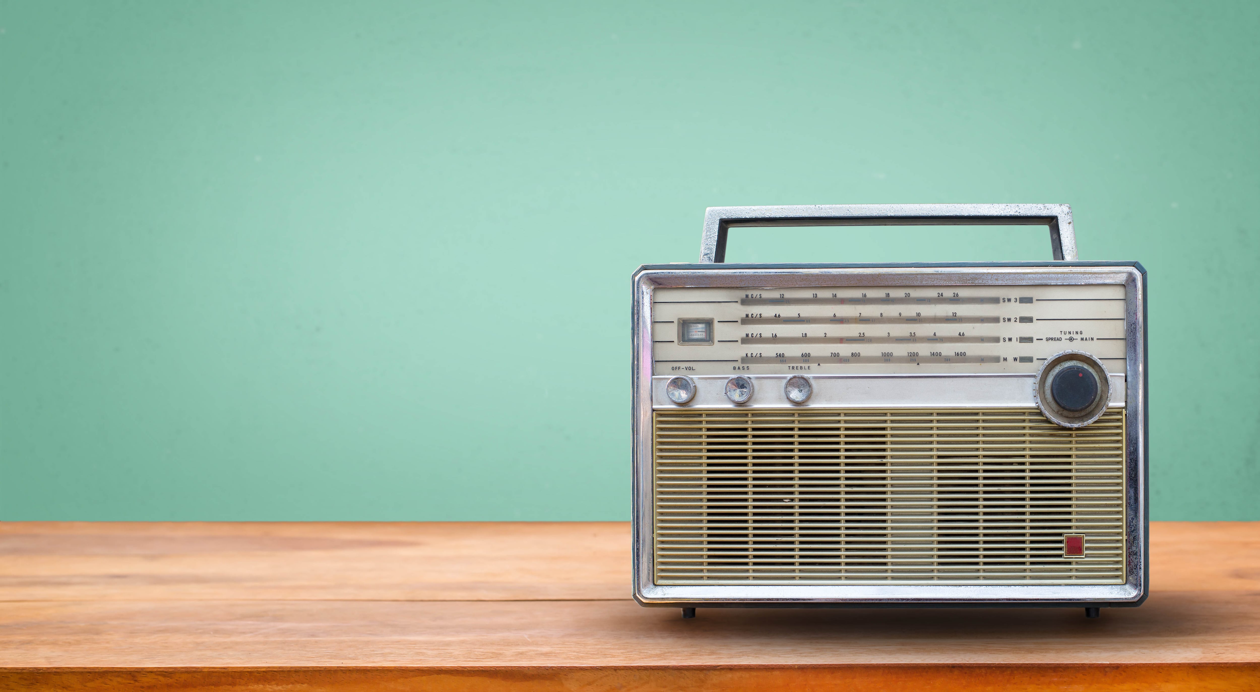 Old retro radio on table with vintage green eye light background