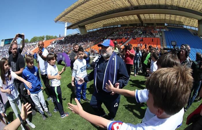 Diego Maradona es recibido por juagdores de las inferiores de Godoy Cruz previo al encuentro entre Gimnasia de La Plata en el Malvinas Argentinas.