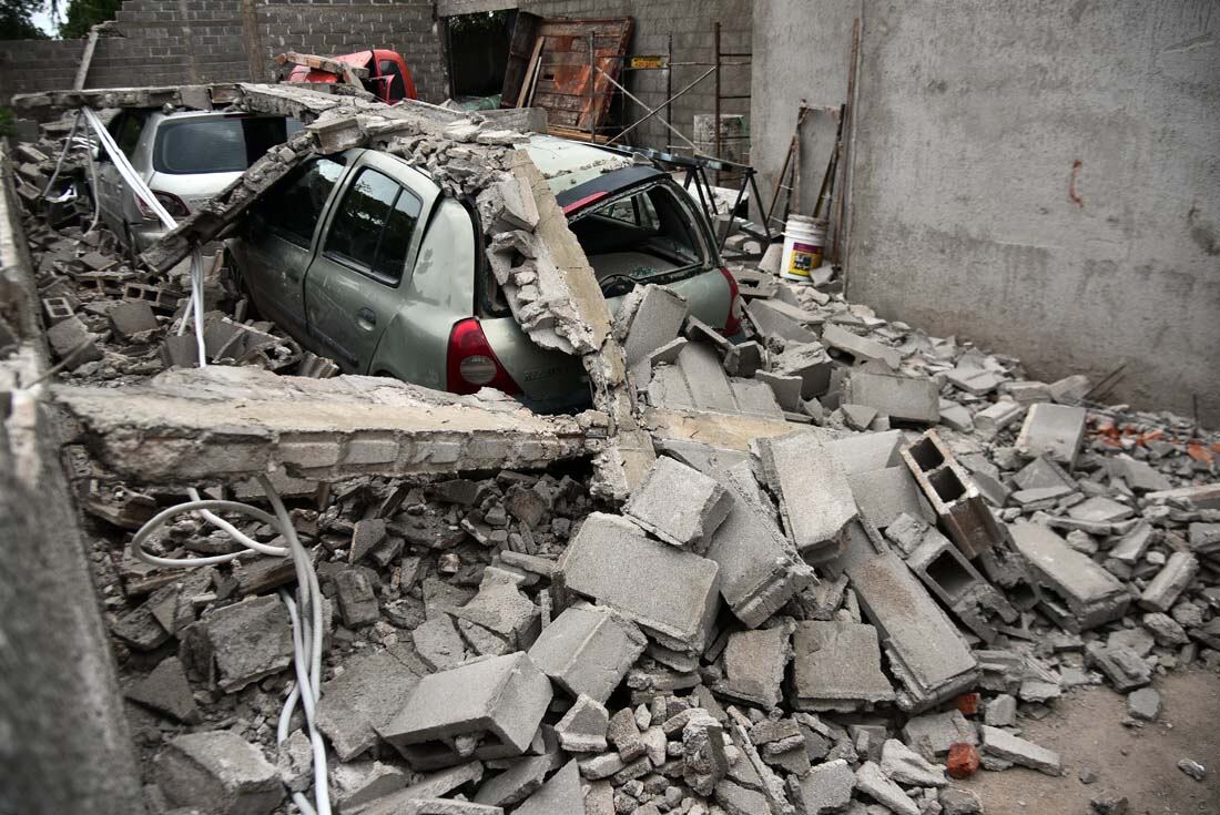 Cuatro autos aplastados al derrumbarse una pared por el fuerte viento en barrio Carcano de la ciudad de Córdoba. El propietario contó que se escuchó una explosión fuerte cuando todo se vino abajo. (Pedro Castillo/ La Voz)