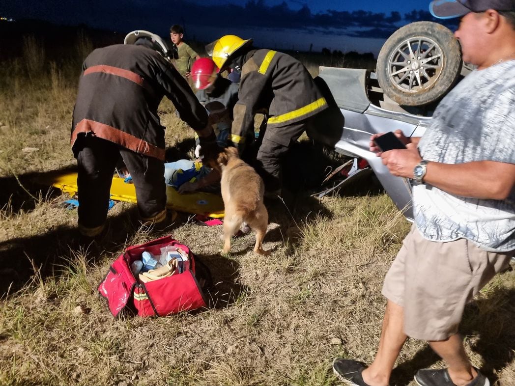 La mascota junto a su dueño mientras es asistido por bomberos.