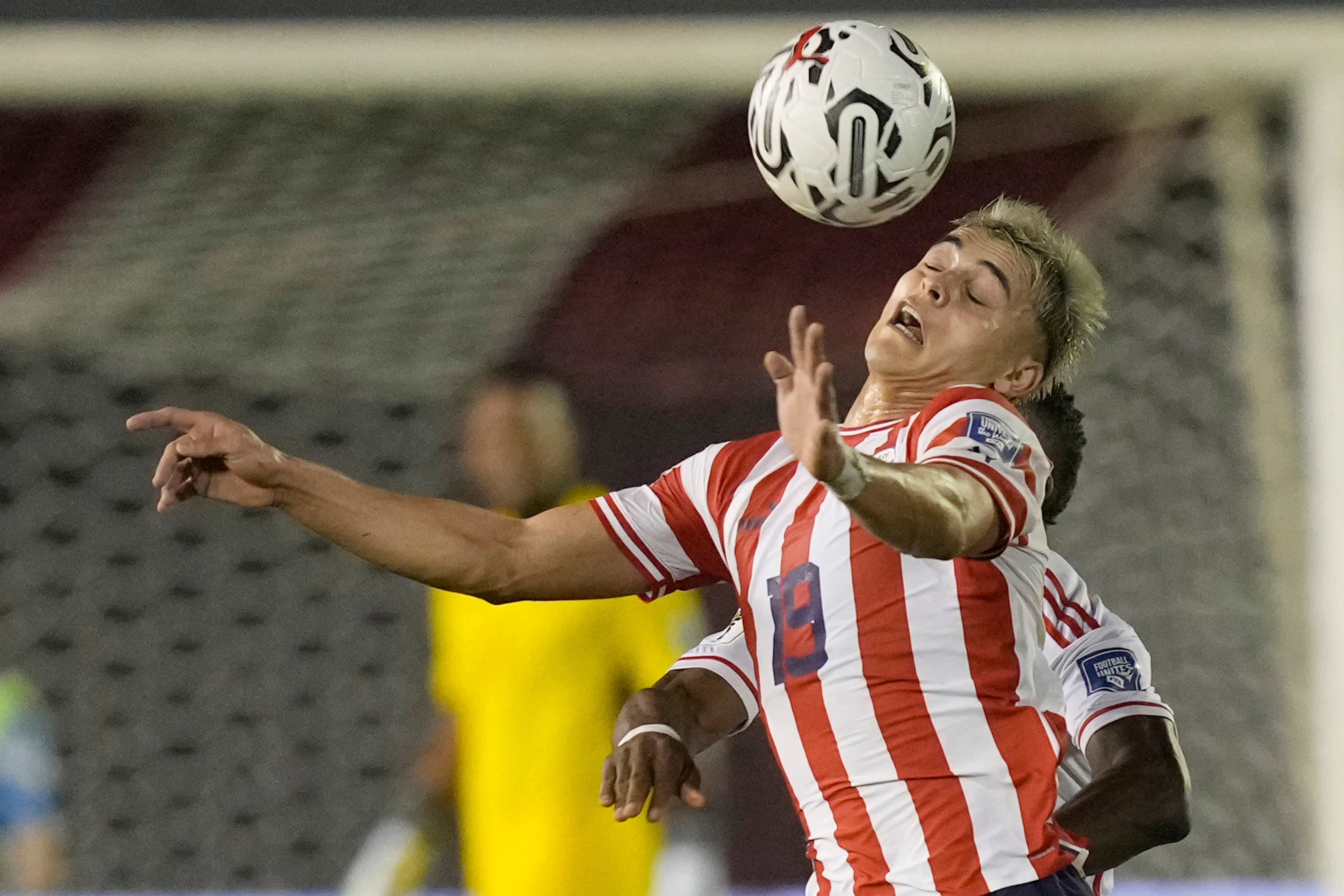 El paraguayo Ramón Sosa trata de controlar el balón ante la marca del peruano Luis Advíncula en el partido por las eliminatorias del Mundial, el jueves 7 de septiembre de 2023, en Ciudad del Este, Paraguay. (AP Foto/Jorge Sáenz)