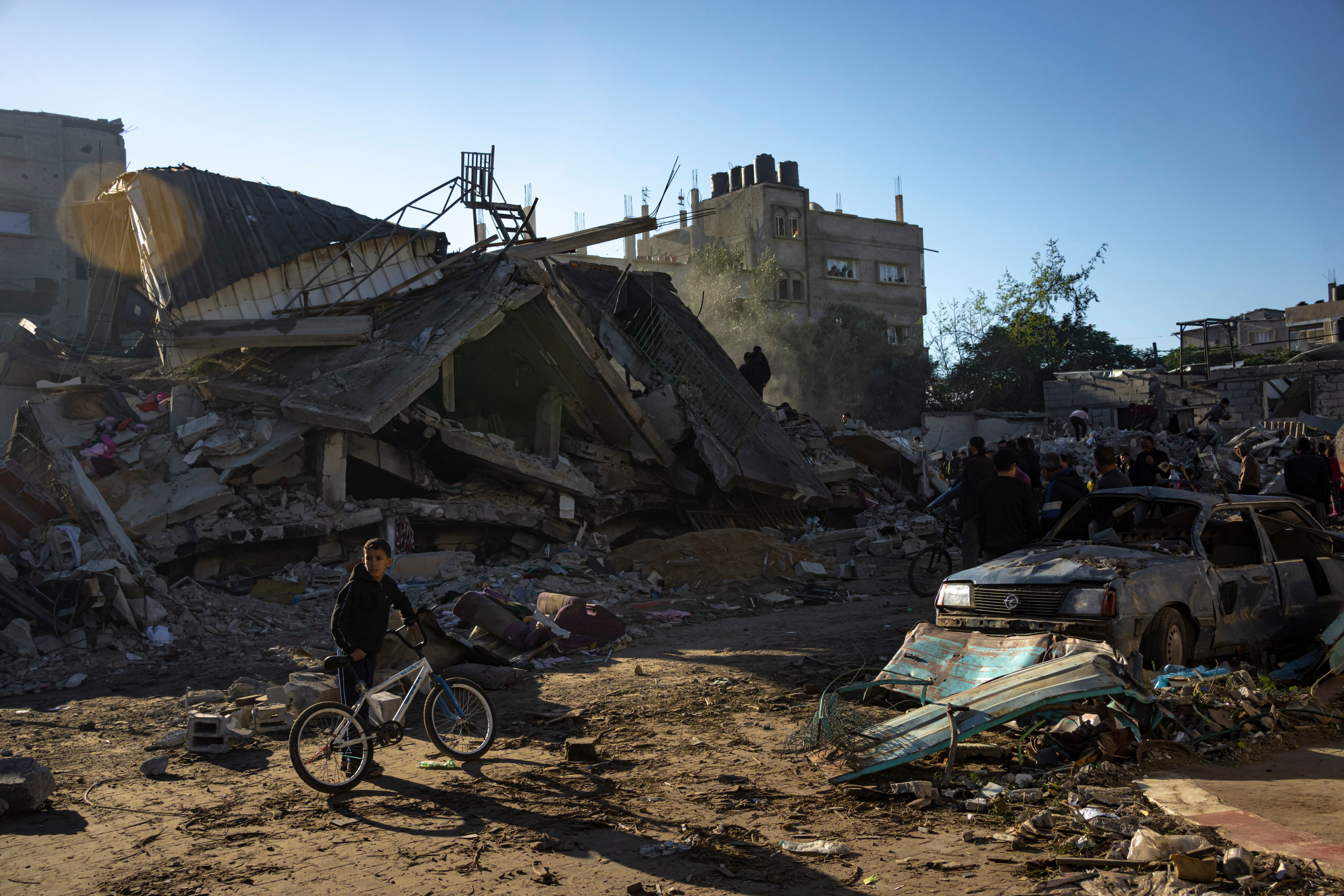 Palestinos buscan cadáveres y sobrevivientes entre los escombros de un edificio residencial destruido en un ataque aéreo de Israel, en Rafah, en el sur de la Franja de Gaza, el 15 de diciembre de 2023. 