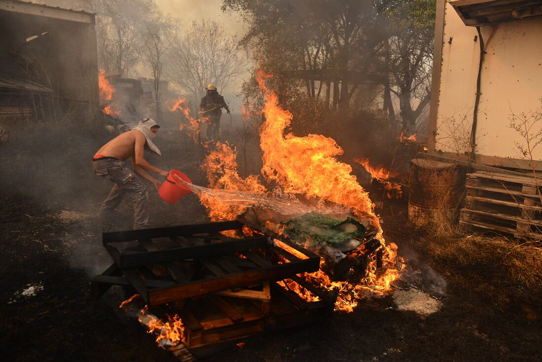 Incendio en una vivienda en Chacras de la Merced. Vecinos combaten las llamas que llegaron a una casa. (José Gabriel Hernández)