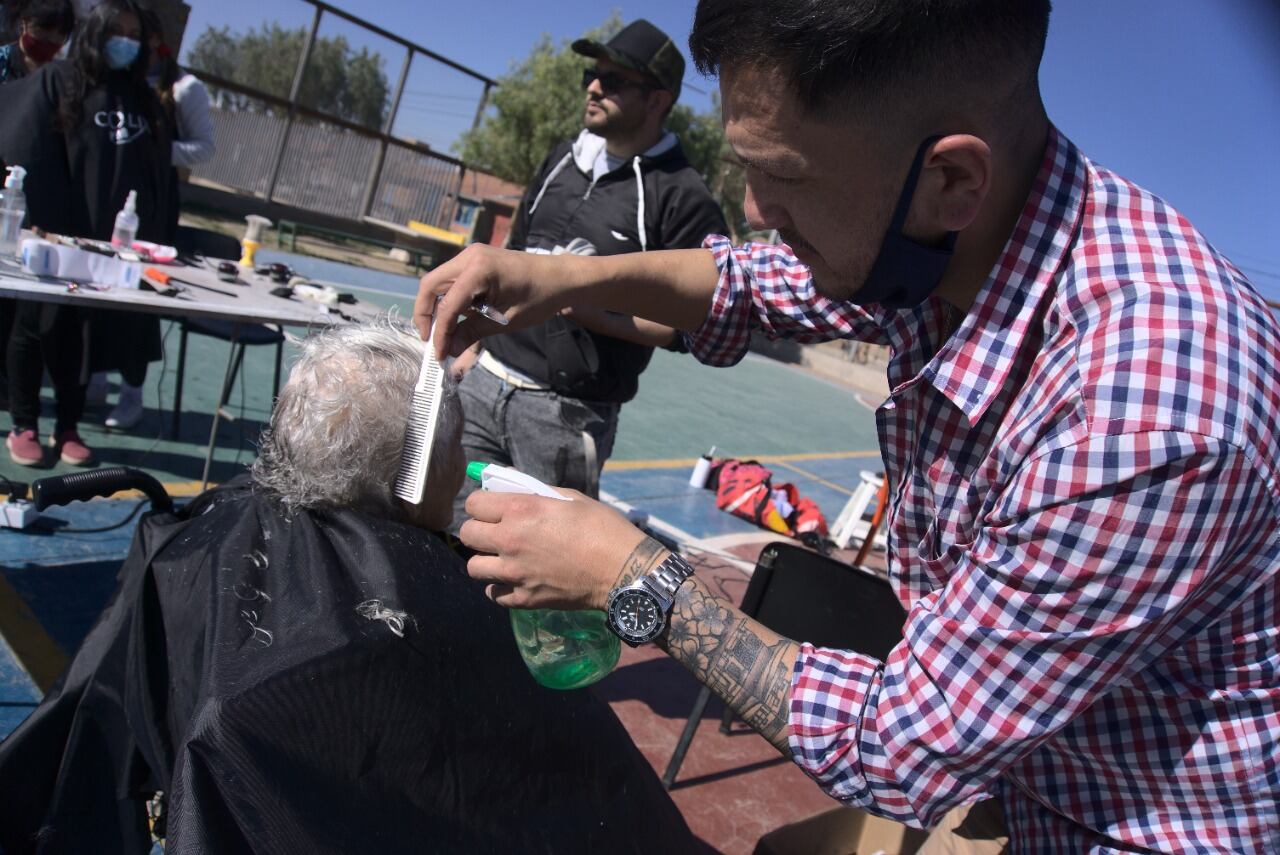 Cristian, uno de los Barberos Solidarios de Mendoza, en medio de una de las convocatorias para cortar el pelo y contagiar de alegría a los vecinos.