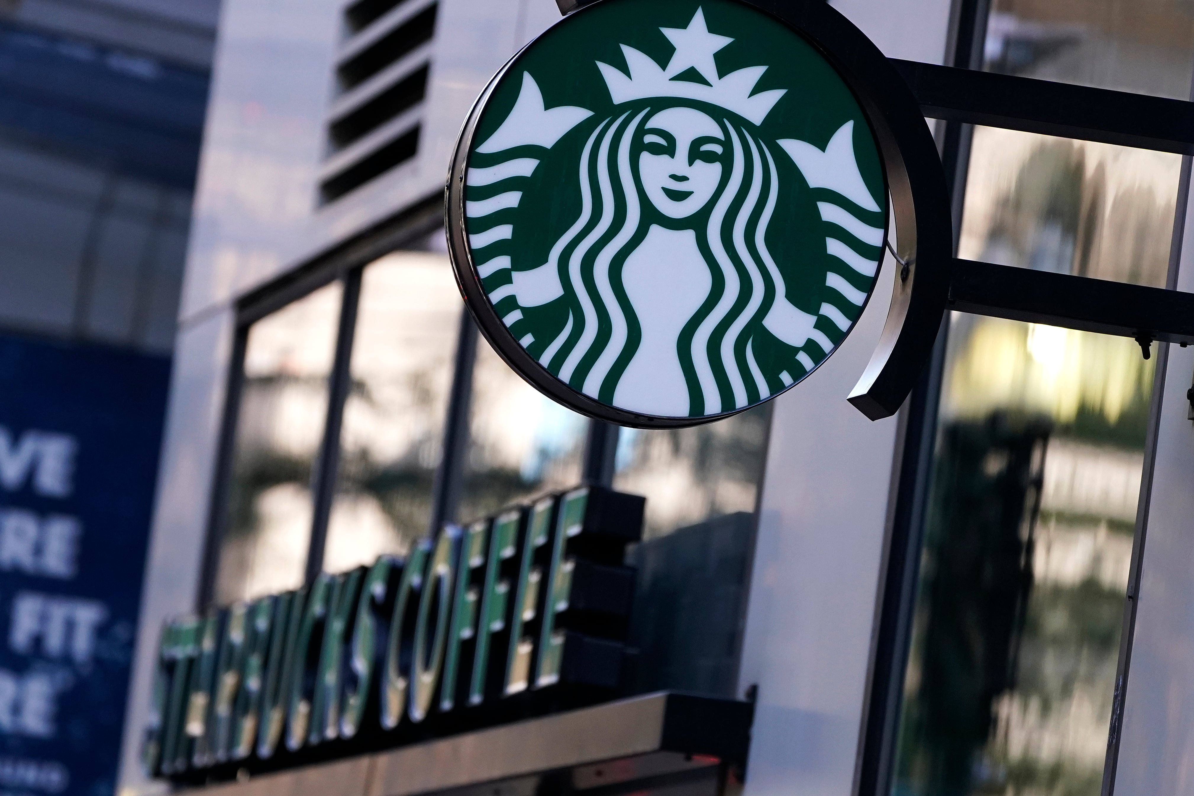 El logotipo de la "Sirena" cuelga fuera de una cafetería Starbucks, el miércoles 14 de julio de 2021, en Boston. (AP Foto/Charles Krupa)