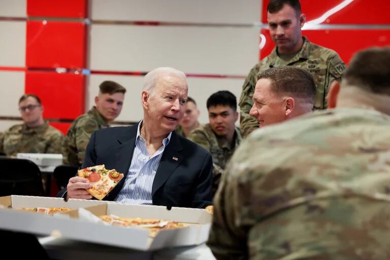 Biden conversa con soldados mientras come pizza (REUTERS/Evelyn Hockstein).