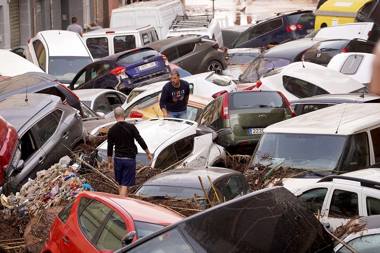 Los residentes observan los autos amontonados luego de ser arrastrados por las inundaciones en Valencia, España, el miércoles 30 de octubre de 2024. (Foto AP/Alberto Saiz)