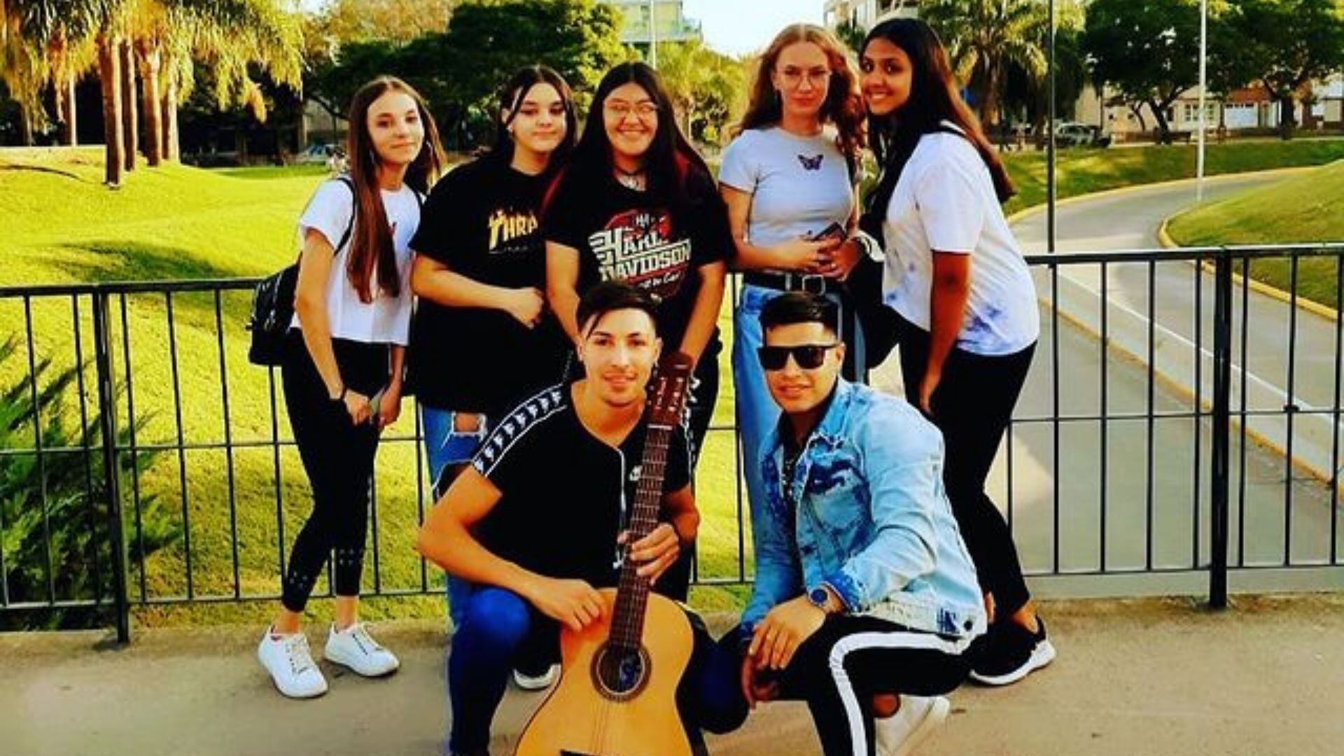 El cantante (quien sostiene la guitarra) junto a un grupo de jovencitas que fueron oyentes de sus canciones.