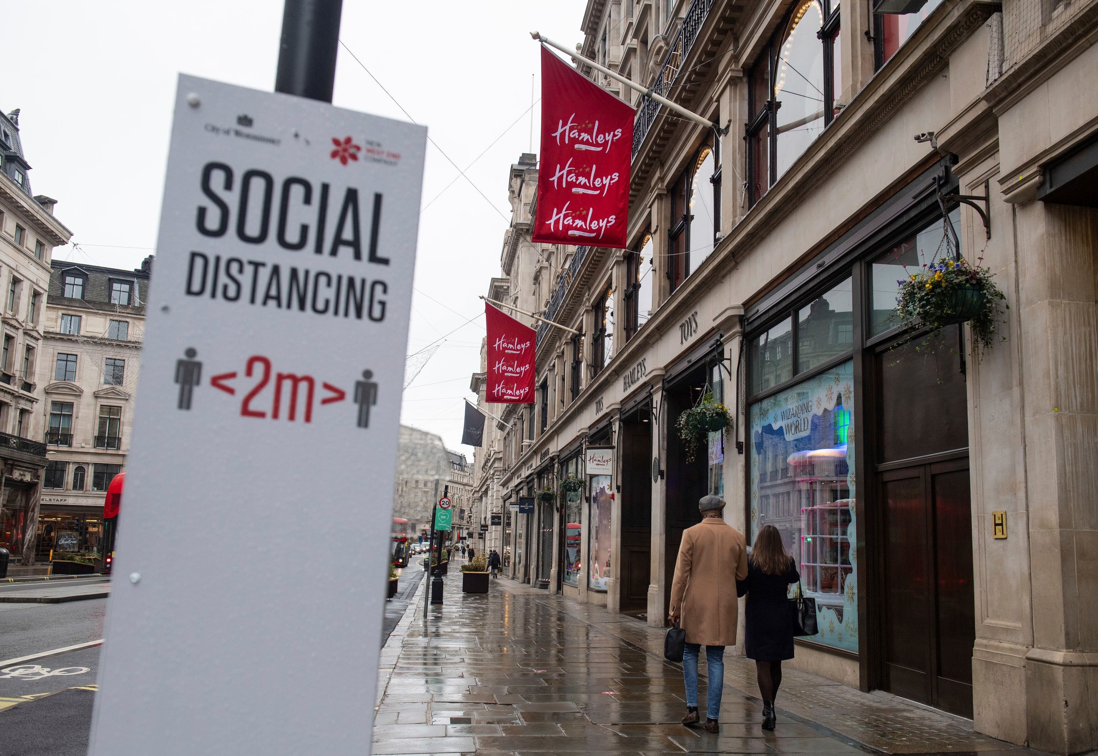 La gente pasa por tiendas cerradas en Regent Street en Londres, que está virtualmente aislada de Europa debido a la nueva cepa de Covid-19.