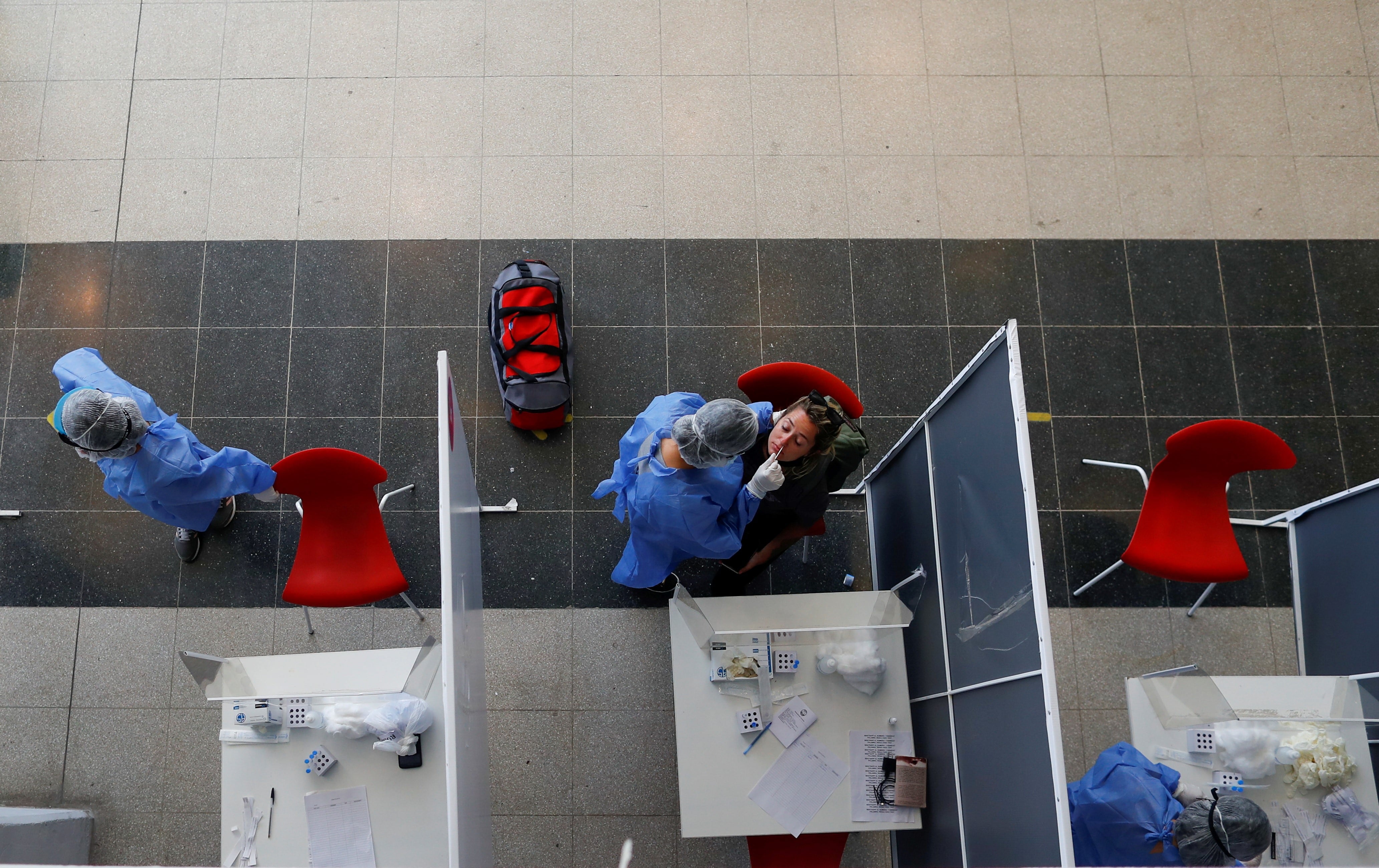 Un trabajador de la salud realiza un hisopado de coronavirus a una mujer en una terminal de autobuses en Buenos Aires. (Foto: REUTERS / Agustin Marcarian)