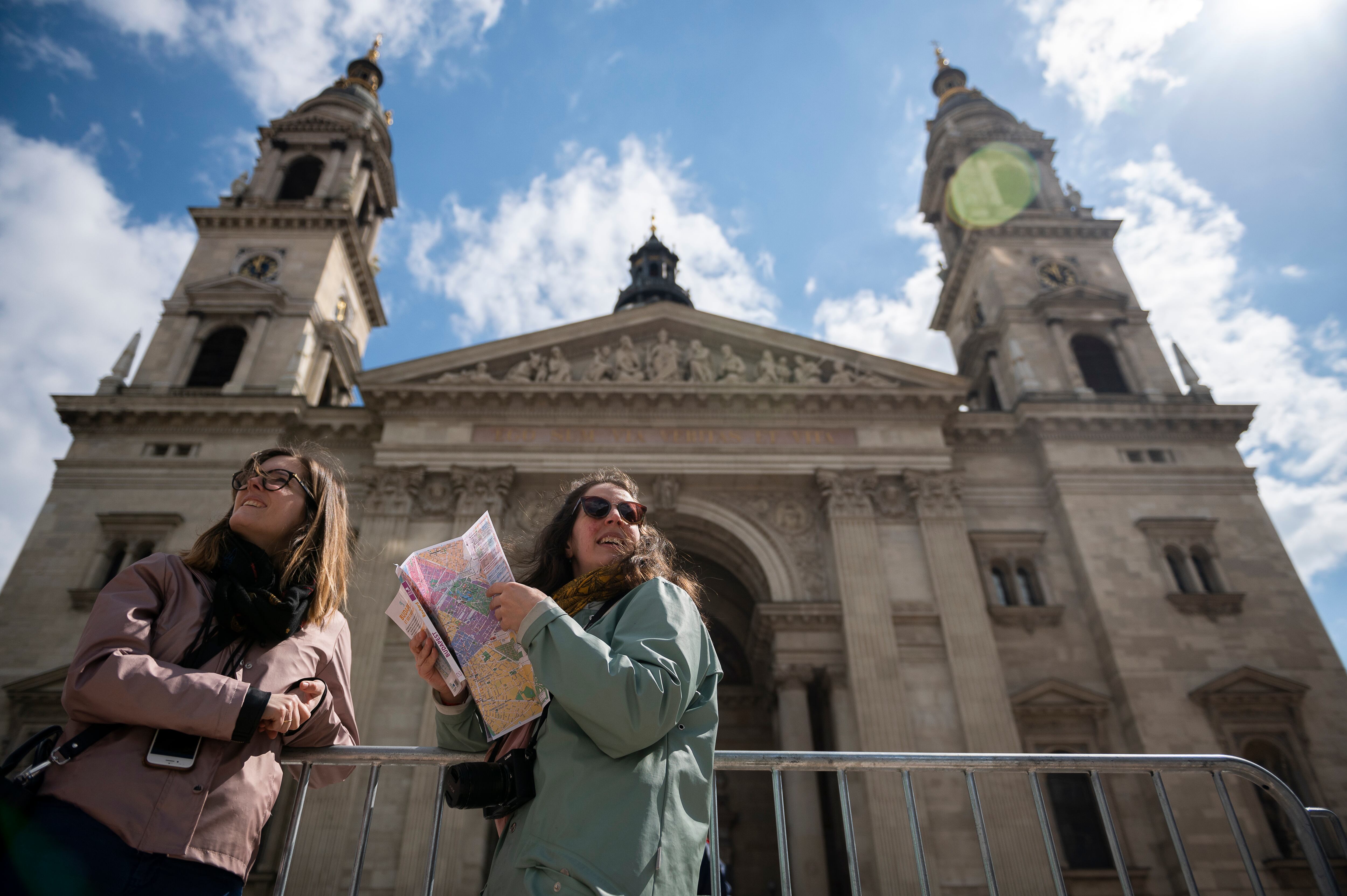 Turistas, junto a la Basílica de San Esteban, en Budapest el 27 de abril de 2023, donde el papa Francisco se reunirá con obispos, sacerdotes y trabajadores pastorales durante su visita de tres días a Hungría. (AP Foto/Denes Erdos)