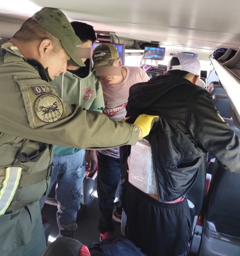 A bordo de colectivo y a la vista de un testigo, los gendarmes descubren la espalda del pasajero que llevaba el paquete sospechoso.