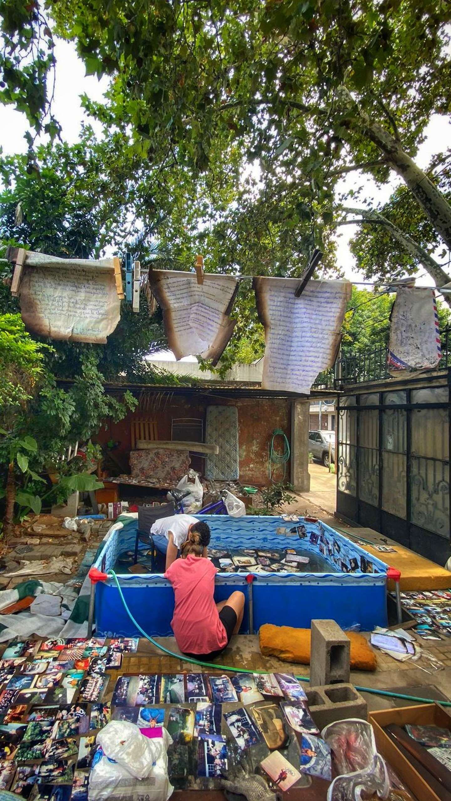 Las mujeres trabajando en el patio de la casa incendiada de Carlitos, tratando de recuperar sus fotografías.