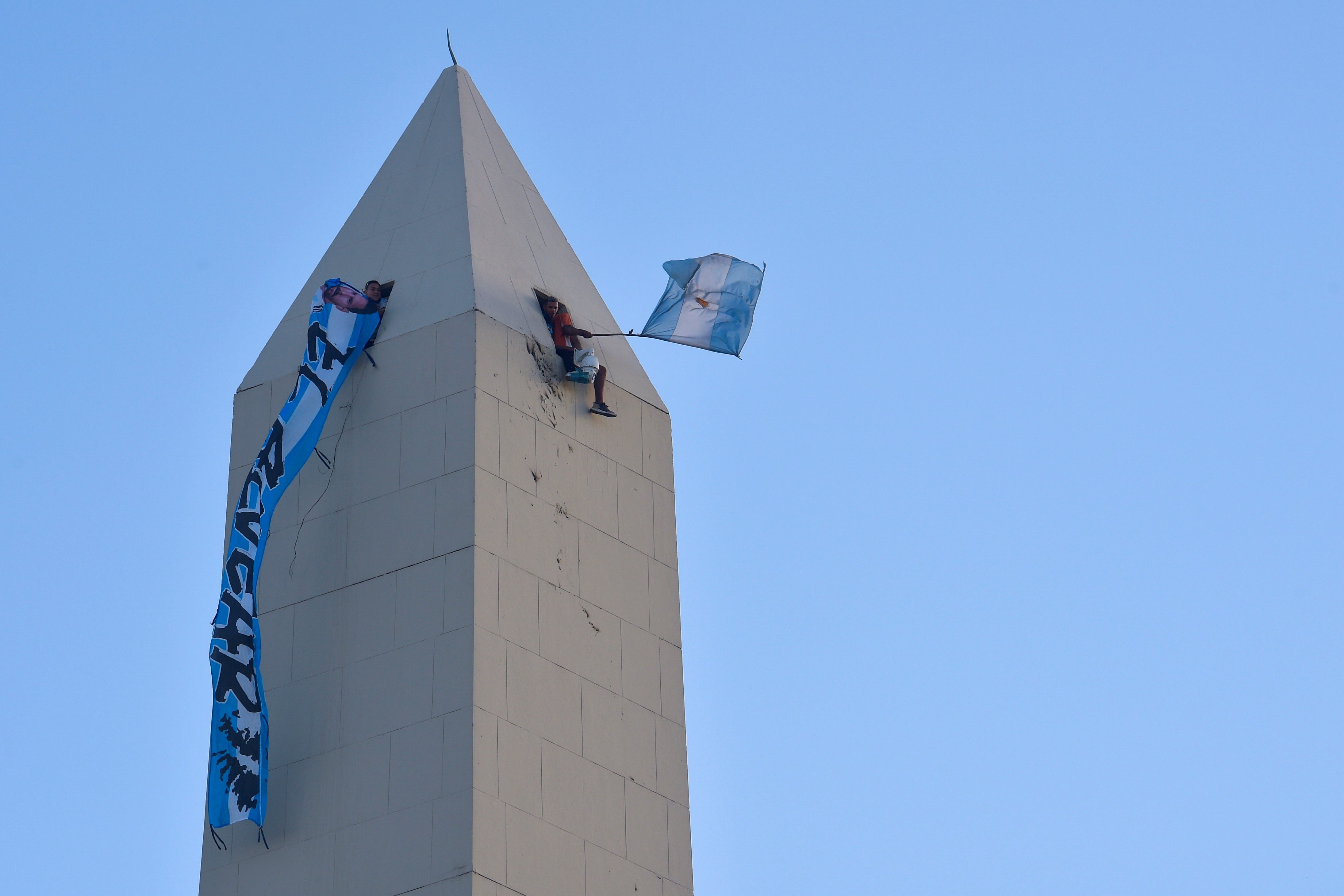 Hinchas trepados en el Obelisco. (AP)