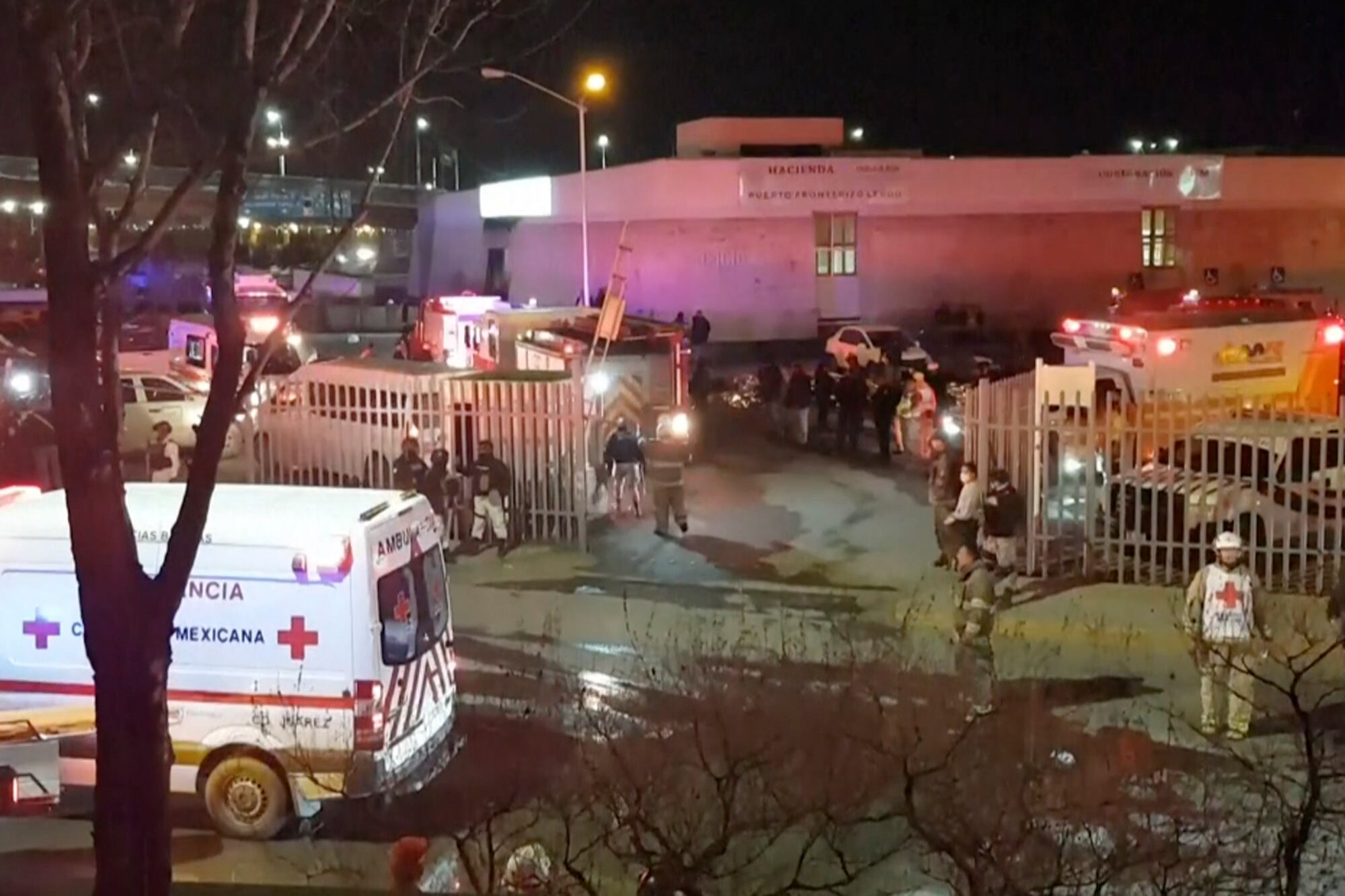 Esta imagen extraída de un video muestra ambulancias y equipos de emergencias ante un centro migratorio en Ciudad Juárez, México, el martes 28 de marzo de 2023. Un incendio en un centro de detención de migrantes en la ciudad fronteriza de Ciudad Juárez, en el norte de México, dejó 39 muertos y 29 heridos, según dijo el martes un funcionario. (AP Foto)