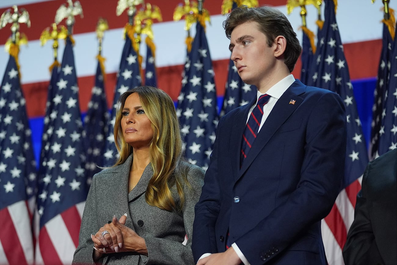 La ex primera dama Melania Trump y Barron Trump escuchan mientras el candidato presidencial republicano, el ex presidente Donald Trump, habla en una fiesta de observación de la noche de las elecciones en el Centro de Convenciones de Palm Beach, el miércoles 6 de noviembre de 2024, en West Palm Beach, Florida. (Foto AP/Evan Vucci)