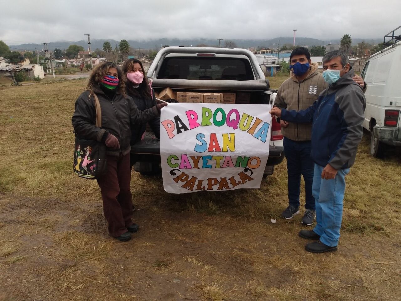 Voluntarios de Cáritas Jujuy, haciendo entrega del azúcar a miembros de la comunidad parroquial de San Cayetano, de Palpalá.