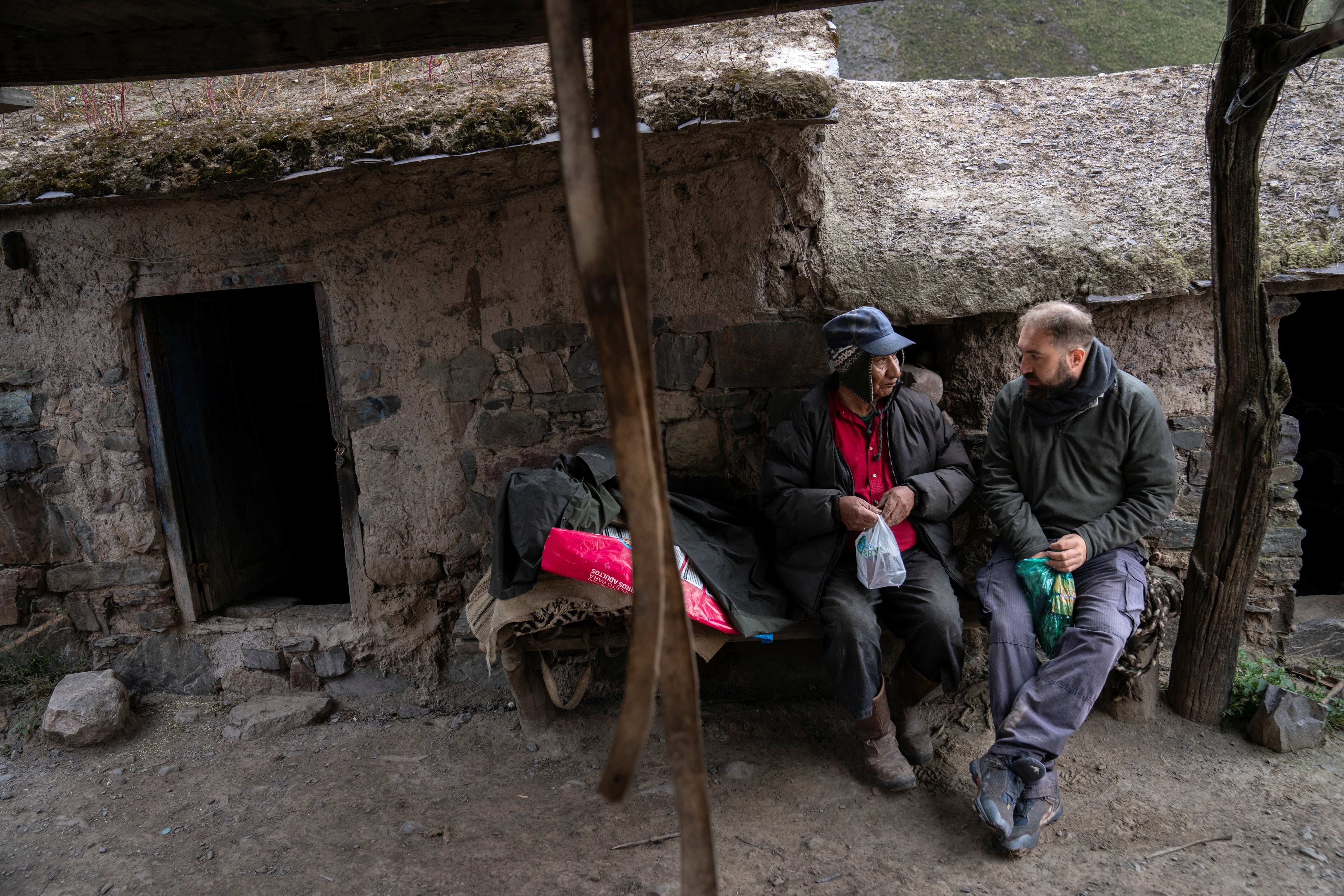 Eduardo Ramos, que vive en Encrucijada, en el Cerro Chañi, sostiene una bolsa con medicamentos que le entregó el Dr. Jorge Fusaro, quien se toma su tiempo para sentarse y compartir hojas de coca con su paciente.