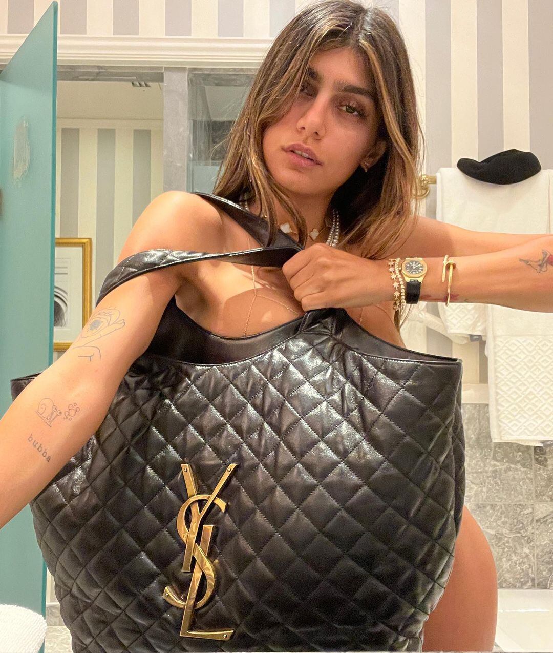 Mia Khalifa posó solamente con un bolso de Yves Saint Laurent para su sesión de fotos.