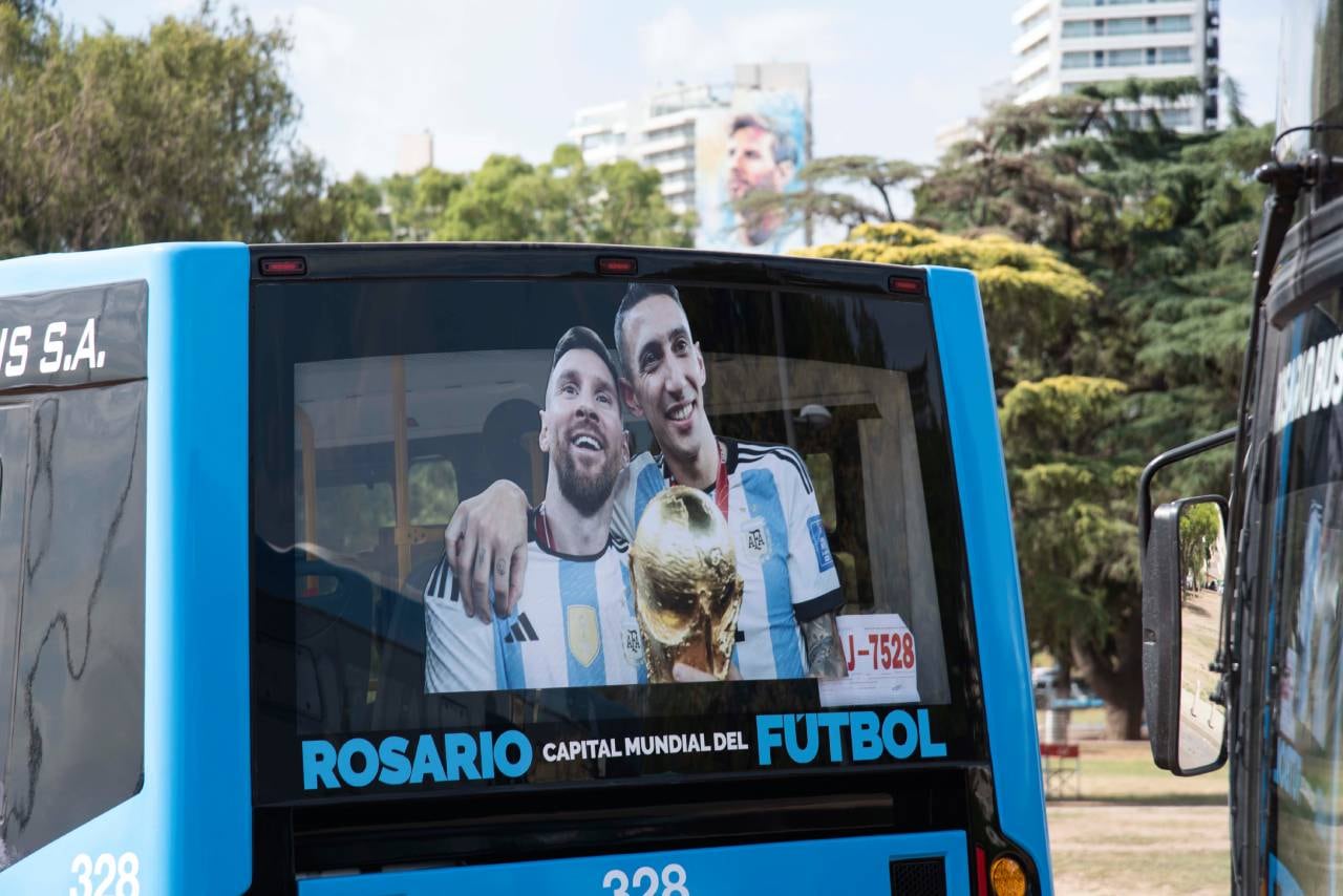 Uno de los colectivos tiene la imagen de la "Pulga" y "Fideo" abrazados con la Copa del Mundo.