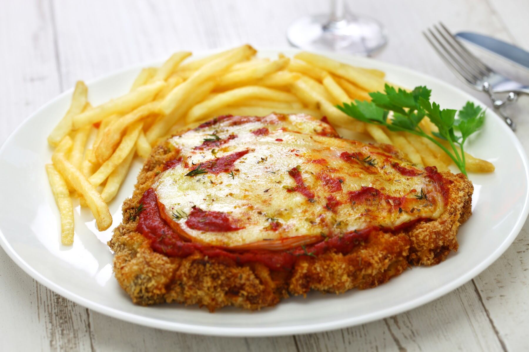 Milanesas de carne con papas fritas a la napolitana. Imagen ilustrativa.