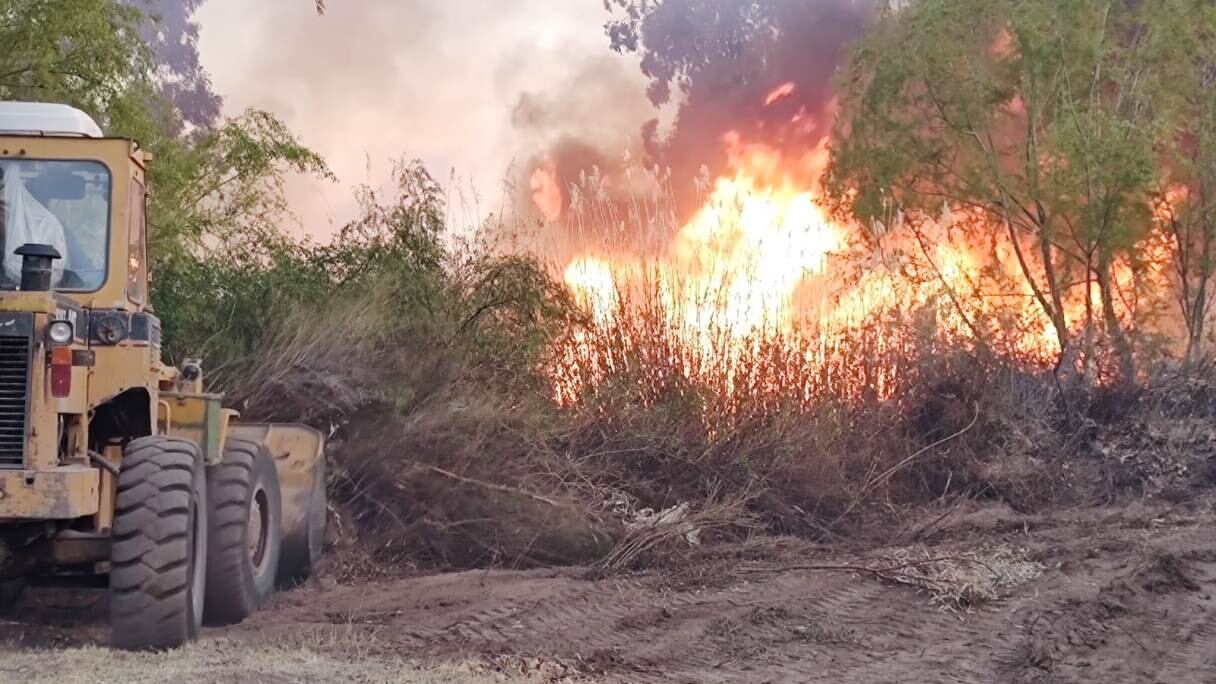 Maquinaria pesada abre picadas cortafuegos para evitgar que avancen las llamas hacia áreas residenciales.