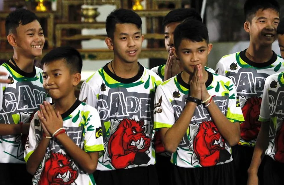 Varios de los doce niños rescatados del interior de una cueva en el norte de Tailandia saludan.
