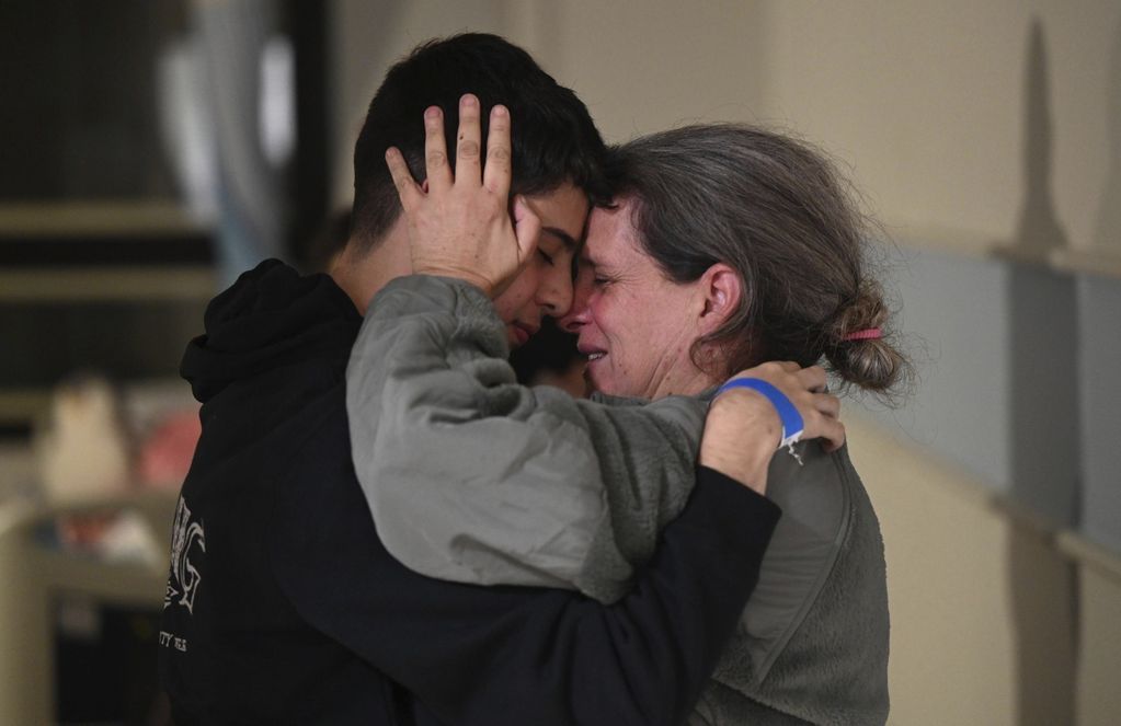 En esta fotografía difundida por Haim Zach/GPO se ve a Sharon Hertzman, a la derecha, abrazando a un familiar después de reunirse en el Centro Médico Sheba, el sábado 25 de noviembre de 2023, en Ramat Gan, Israel. 