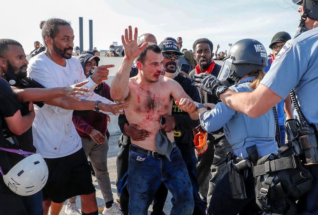 Manifestantes "entregan" al conductor a la policía, después de haber sido atacado (REUTERS/Eric Miller)