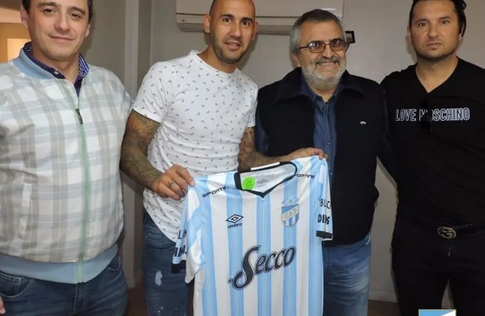 Juan Mercier firmó el contrato que lo liga por un año a Atlético y posó con la camiseta junto a los dirigentes.