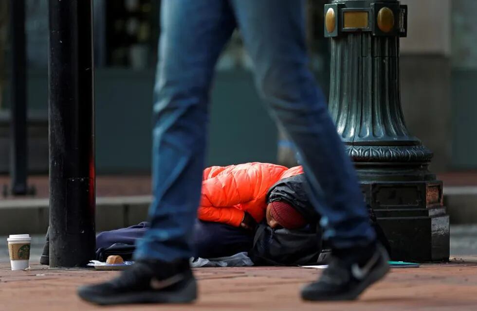 Cheyvonne Price, who says she is homeless primarily due to heroin addiction, naps on a sidewalk outside a Starbucks in downtown Portland, Ore., on Sept. 20, 2017, after spending a night outside on the streets trying to keep dry in the rain. Price said she hoped to get enough money during the day to afford a bed at a hostel for the night and said that she wishes people would realize that the homeless \