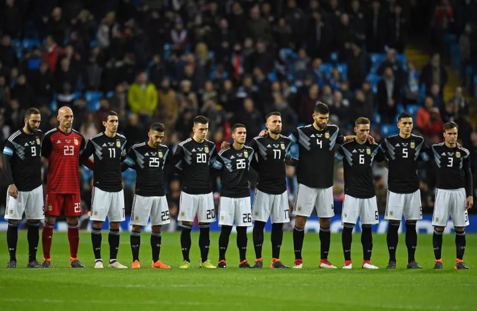 Argentina players observe a minute of silence for Italian player Davide Astori ahead of the International friendly football match between Argentina and Italy at the Etihad stadium in Manchester, north west England on March 23, 2018. / AFP PHOTO / Oli SCARFF
