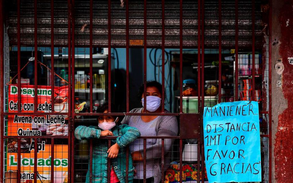 Una mujer atiende su negocio con tapabocas en el Barrio 31 de Retiro (Foto: Ronaldo SCHEMIDT / AFP)