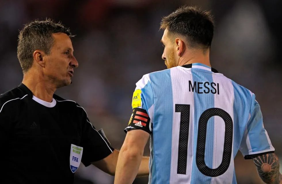 Argentina's forward Lionel Messi (R) argues with Brazilian first assistant referee Emerson Augusto de Carvalho during the half time of their 2018 FIFA World Cup Russia South American qualifier football match against Chile, at the Monumental stadium in Bue