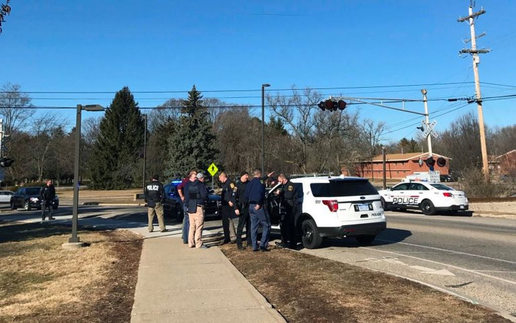 Authorities stand on the campus of Central Michigan University during a search for a suspect, in Mount Pleasant, Mich., Friday, March 2, 2018. School officials say police are responding to a report of shots fired at a residence hall at the university. (Lisa Yanick Litwiller/The Morning Sun via AP)