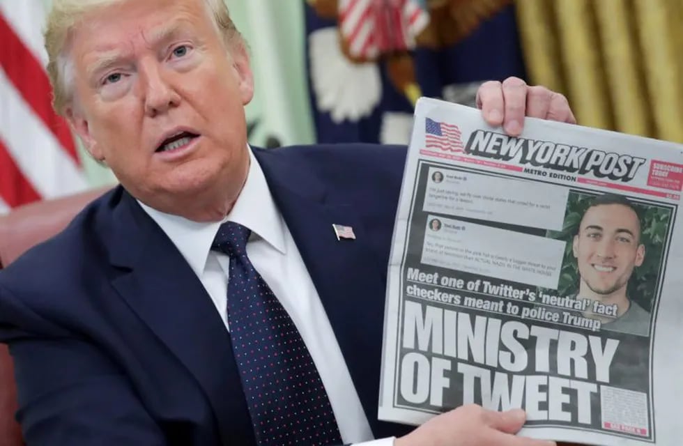 FILE PHOTO: U.S. President Donald Trump holds up a front page of the New York Post as he speaks to reporters while discussing an executive order on social media companies in the Oval Office of the White House in Washington, U.S., May 28, 2020. REUTERS/Jonathan Ernst/File Photo