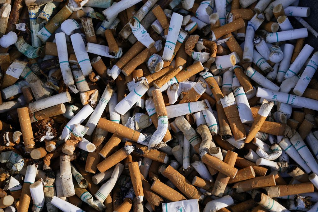 ARCHIVO - Restos de cigarrillos llenan un recipiente ante un edificio federal en Washington, el jueves 15 de abril de 2021. Los adultos en Estados Unidos fuman menos, según un sondeo del gobierno publicado el jueves 27 de abril de 2023. (AP Foto/J. Scott Applewhite, Archivo)