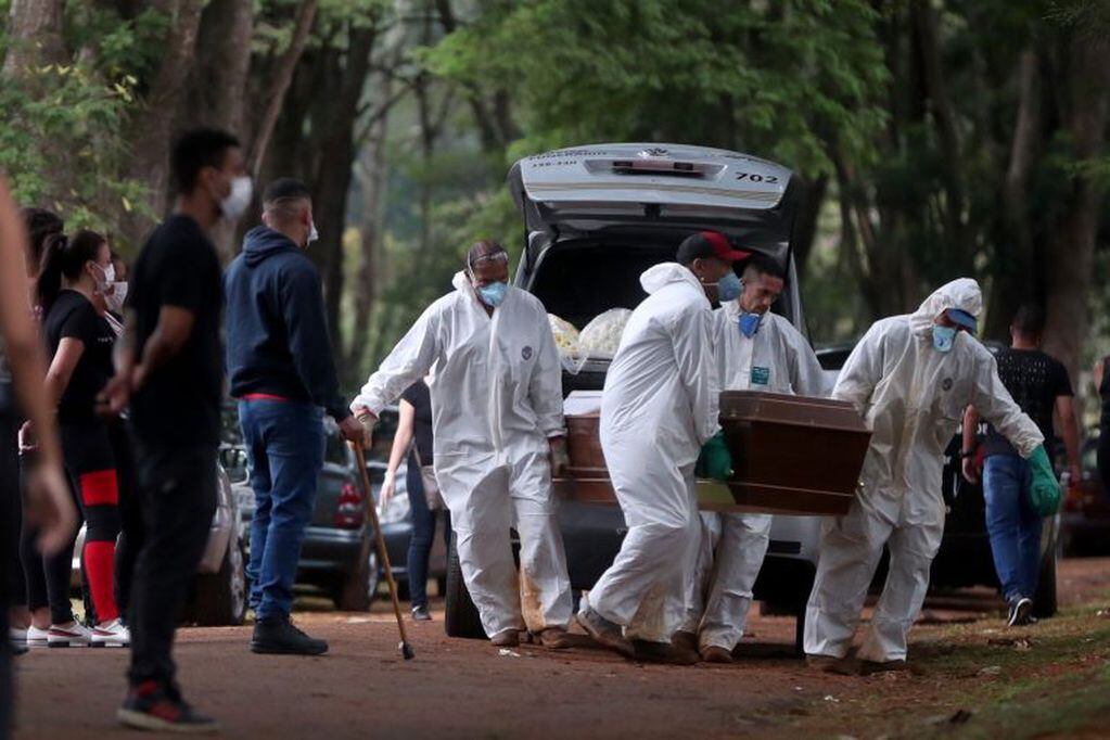 Empleados del servicio funerario entierran a una víctima de COVID-19 en San Pablo, Brasil. (Foto: Fernando Bizerra/EFE)