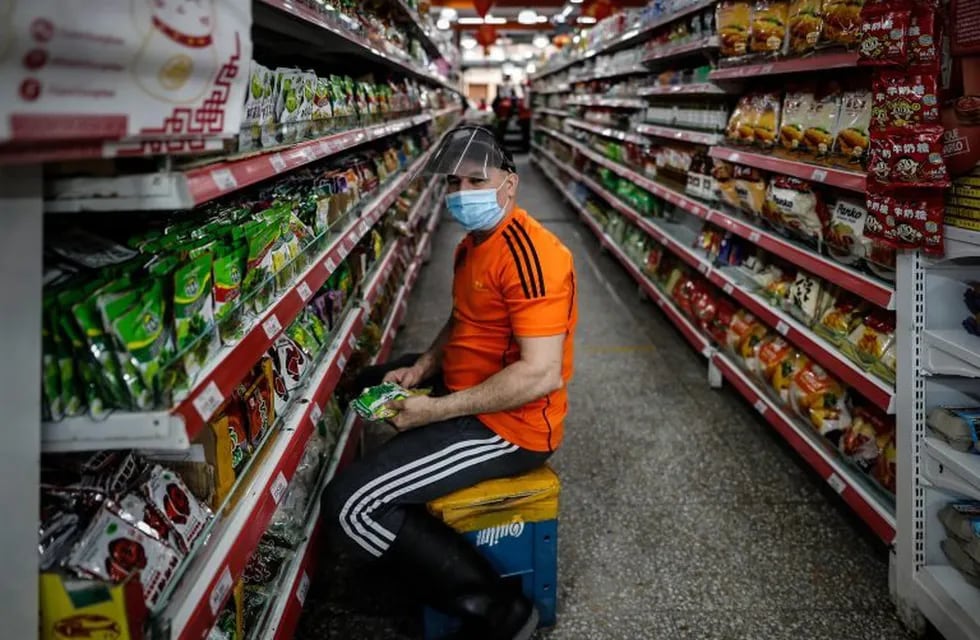 Un trabajador de un supermercado usa tapabocas. (EFE)