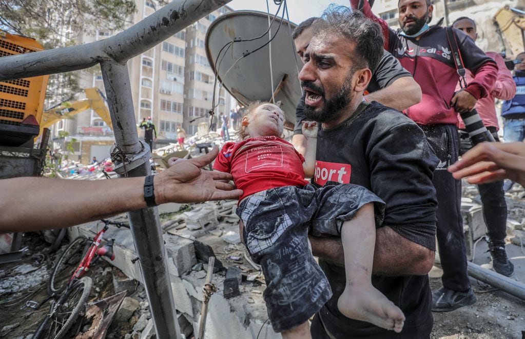 Un palestino lleva el cuerpo sin vida de su hija tras sacarlo de entre los escombros de un edificio destruido en un ataque aéreo en ciudad de Gaza.