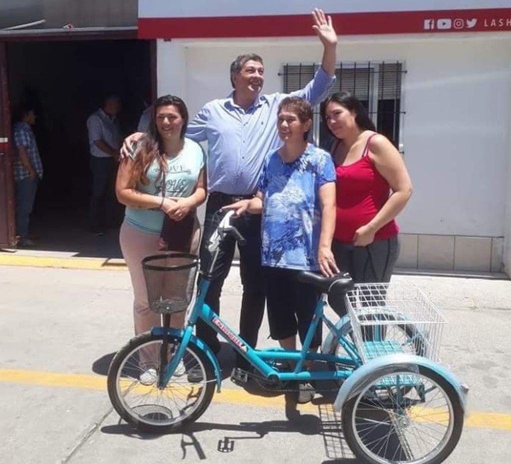 El intendente de Las Heras, Daniel Orozco, le hace entrega de la bicicleta, modificada, para que  Miryam Argone pueda seguir trabajando.