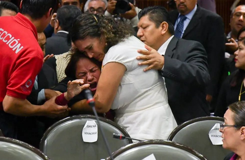 Legisladores intentan calmar a la diputada Carmen Medel Palma, del Movimiento Regeneración Nacional (Morena), luego de que recibiera la noticia de que su hija había sido asesinada. EFE/STR