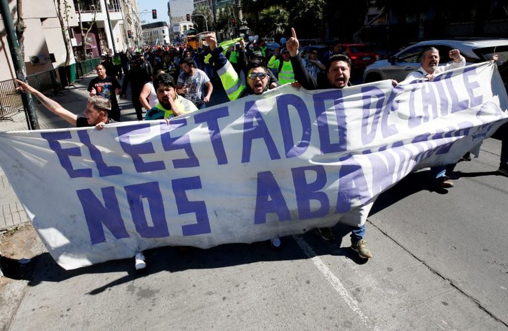 Dockworkers hold a banner that reads "The State of Chile abandoned us" as they take part in a protest against Chile's state economic model in Valparaiso, Chile, October 21, 2019. REUTERS/Rodrigo Garrido