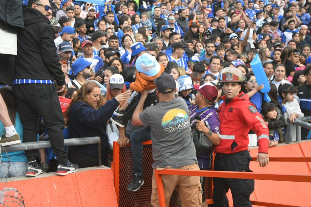 Los hinchas de Godoy Cruz le escapan al gas pimienta que tiró la pelicía en las afueras del estadio para dispersar a la barra / José Gutiérrez.